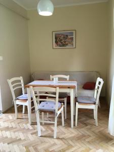 una mesa y sillas en una habitación con sofá en Csillagkert Vendégház, en Kaposszerdahely