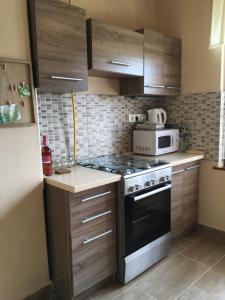 a kitchen with a stove and a microwave at Csillagkert Vendégház in Kaposszerdahely