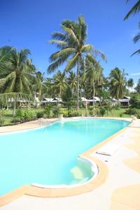 a large swimming pool with palm trees in the background at Phangka Paradise Resort in Taling Ngam Beach