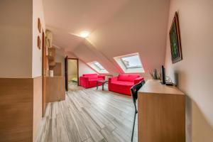 uma sala de estar com cadeiras vermelhas e uma mesa em Garni Citi Hotel Veliki em Novi Sad
