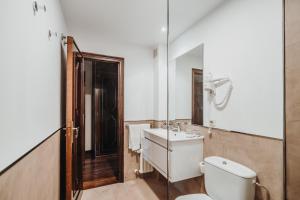 a bathroom with a toilet and a sink and a mirror at Pazo da Touza in Nigrán