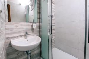 
a bathroom with a sink and a shower at Garni Citi Hotel Veliki in Novi Sad
