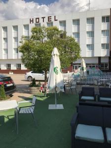 a hotel with tables and chairs and an umbrella at Hotel Buenos Aires in Villafr&iacute;a de Burgos