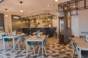 a restaurant with tables and chairs and a kitchen at Hotel degli Amici in Artena