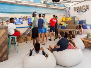 a group of people sitting on bean bags in a room with a beach at Ramada Hotel & Suites by Wyndham Costa del Sol in Fuengirola