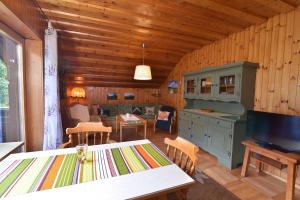 een woonkamer met een tafel en een tv in een hut bij Ferienwohnung Waldheimat in Bayerisch Eisenstein