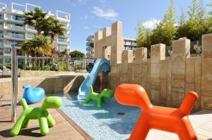 a park with a pool, chairs, and a pool table at Blaumar Hotel in Salou
