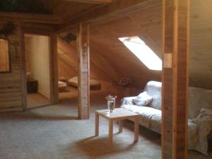 a room with a couch and a table in a attic at Apartamenty Pod Lipami in Junoszyno
