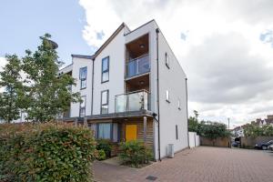 una casa blanca con puerta amarilla en Rowan Park Lodge, en Croydon