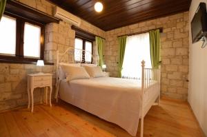 a bedroom with a bed and a tv and windows at Alayaz Hotel in Alacati