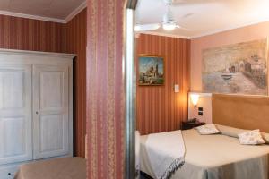 - une chambre avec un lit et une peinture murale dans l'établissement Holiday Rooms Antica Badia, à Volterra