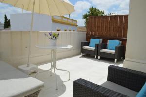 a patio with a table and chairs and an umbrella at Apartament Año Feliz in Jerez de la Frontera