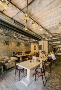 a restaurant with wooden ceilings and tables and chairs at Garni Citi Hotel Veliki in Novi Sad