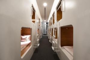 a corridor of beds in a train car at KINI Capsule in Jakarta