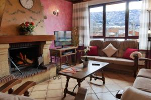 sala de estar con sofá y chimenea en Casas Rurales Florentino, en Robledillo