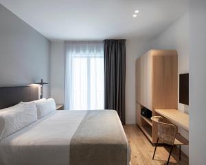 a hotel room with a bed and a television at Alta House Begur in Begur