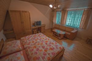 1 dormitorio con cama, sofá y TV en Penzión Weinerovka Varín, en Žilina