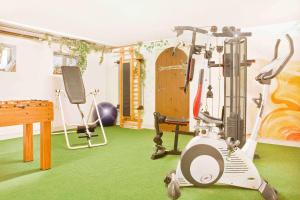 a room with a gym with a treadmill and a table at Schlossberghof in Marktrodach