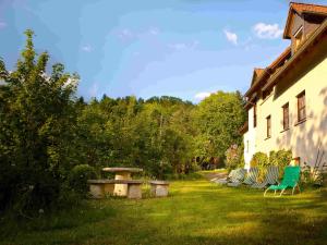 a green bench sitting in the grass next to a building at Schlossberghof in Marktrodach
