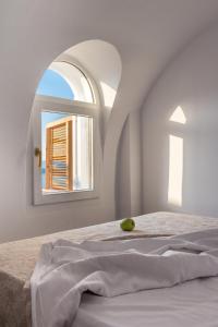 a bedroom with a bed with an arch window at Summer Lovers Villa in Akrotiri