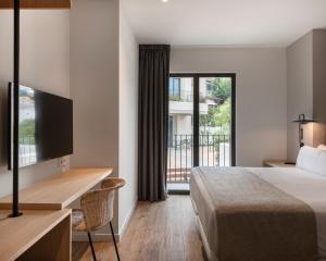 a hotel room with a bed and a balcony at Alta House Begur in Begur