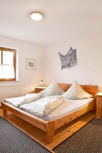 Un dormitorio con una gran cama de madera con almohadas en Schlossberghof, en Marktrodach