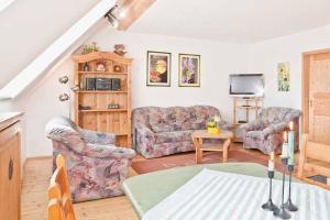 a living room with two couches and a table at Schlossberghof in Marktrodach