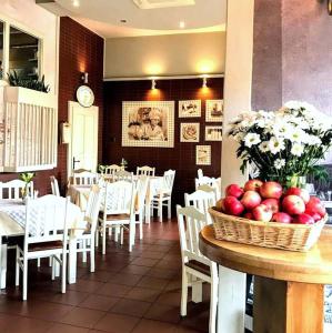 a dining room with tables and chairs and a basket of apples at Pokoje Przy Plaży in Mielno