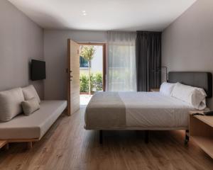 a bedroom with a bed and a couch and a window at Alta House Begur in Begur