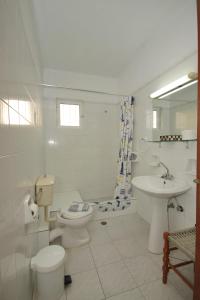 a white bathroom with a toilet and a sink at Filoxenia in Paralio Astros