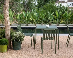 a green table and two chairs next to a tree at Alta House Begur in Begur