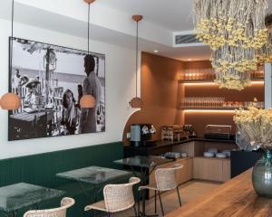 a dining room with tables and chairs and a picture on the wall at Alta House Begur in Begur