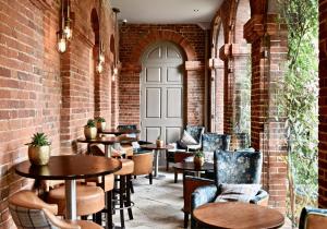 a restaurant with tables and chairs in a brick wall at Lainston House in Winchester
