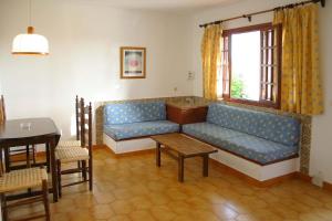 a living room with a blue couch and a table at APARTAMENTOS SON BOU Z5 in Son Bou