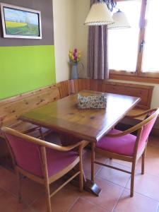 mesa de comedor con 2 sillas y mesa de madera en Apartaments La Bonaigua en Valencia de Aneu