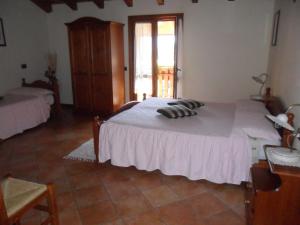 a bedroom with a large white bed and a window at I Camuni in Capo di Ponte