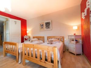 オストハイムにあるAu pré des Poulainsの赤い壁のベッドルームにベッド2台が備わります。