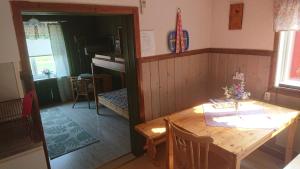 a dining room with a wooden table and a table and chairs at Kolbacken stugby & Camping in Åsarne