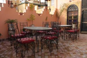 a group of tables and chairs in a courtyard at Riad Benchekroun in Meknès