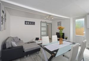 a dining room and living room with a table and chairs at Le Franche Comté Centre Ville Rive Droite in Laval