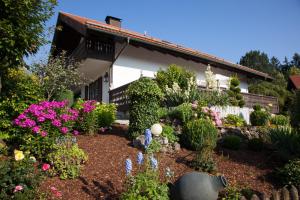 a garden in front of a house with flowers at Romantik Villa in Andechs