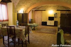 a room with a table and chairs and a television at Lo Sfizio B&B in Cupramontana