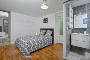 1 dormitorio con 1 cama y baño con lavamanos en Le Franche Comté Centre Ville Rive Droite, en Laval