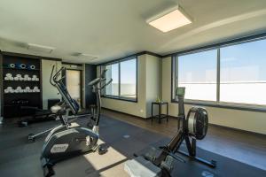 a gym with two exercise bikes in a room with windows at HF Ipanema Porto in Porto