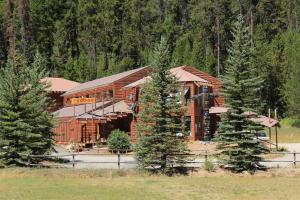 a large log cabin with trees in front of it at The Lodge at Lolo Hot Springs in Lolo