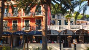 a hotel with palm trees in front of a building at Piccolo Hotel in Moneglia