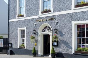 um edifício cinzento com uma placa que lê servidores hotel em Dingle Benners Hotel em Dingle