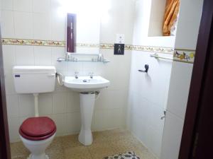 uma casa de banho com um WC e um lavatório em Cardamom House em Sembatti