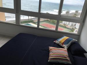 a bed in a room with a view of the ocean at Apartamento frente al mar in Algarrobo-Costa +42 photos
