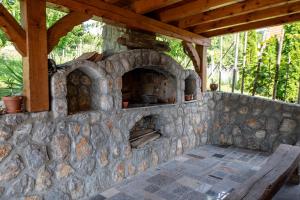 un horno al aire libre con una pared de piedra y un banco en Vineyard Cottage Pod Piramido, en Dobrnič